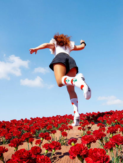 Person trägt weiße Freedom Socken mit roten Nelkenmotiven