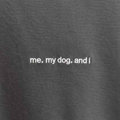 Nahaufnahme der weißen Stickerei me. my dog. and i auf verwaschenem schwarzem Baumwollstoff
