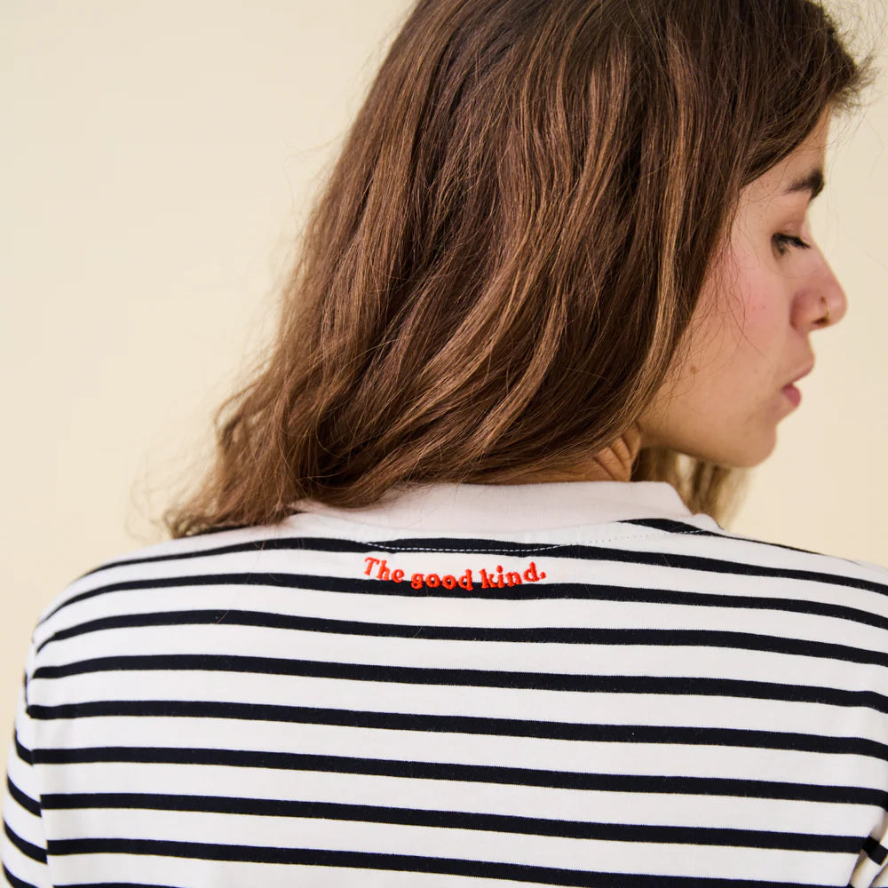 Rückansicht des gestreiften popeia Langarmshirts in Schwarz und Off-White mit rotem Kindness-Spruch im Nacken.