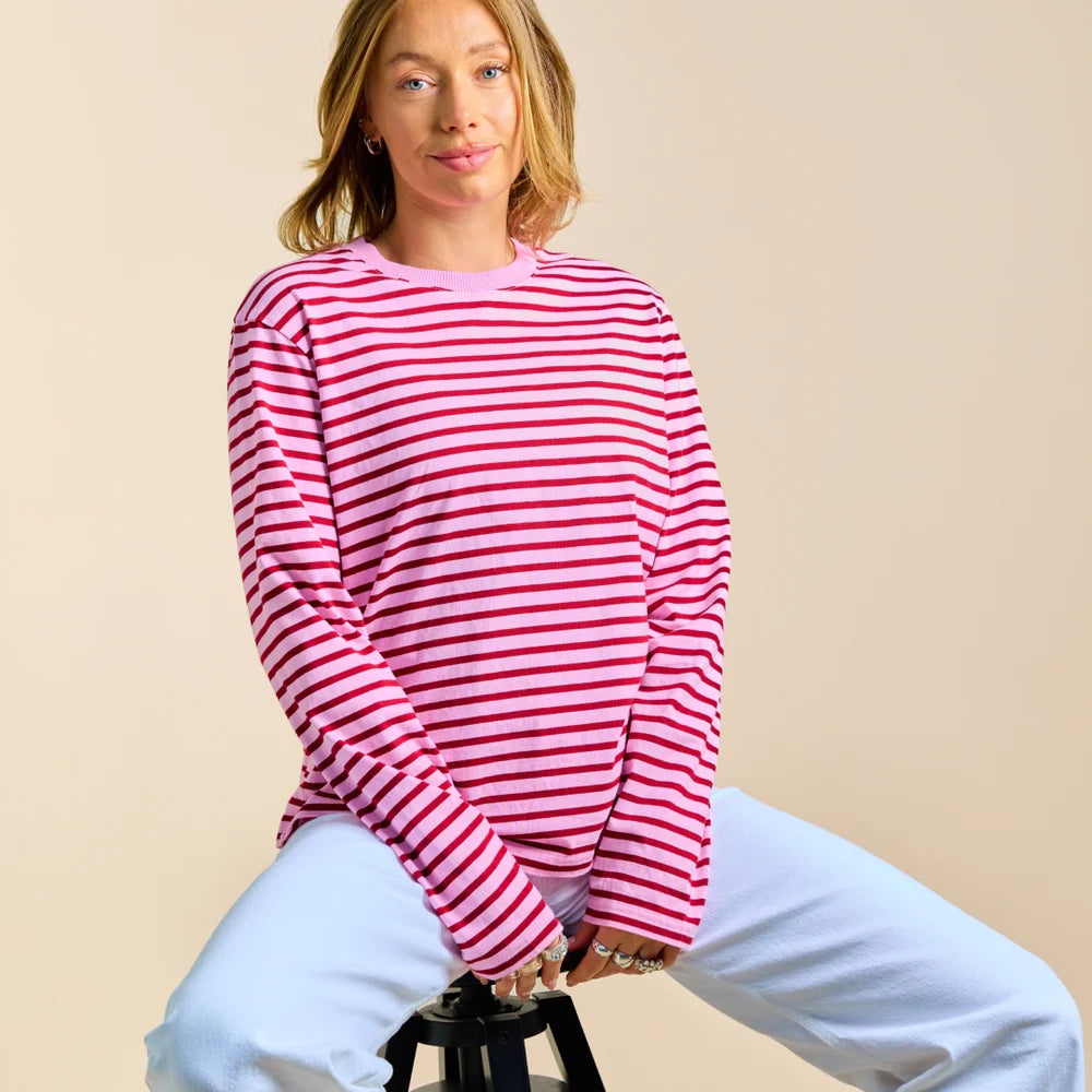 Gestreiftes Bio-Langarmshirt in Pink und Bordeaux beim Sitzen