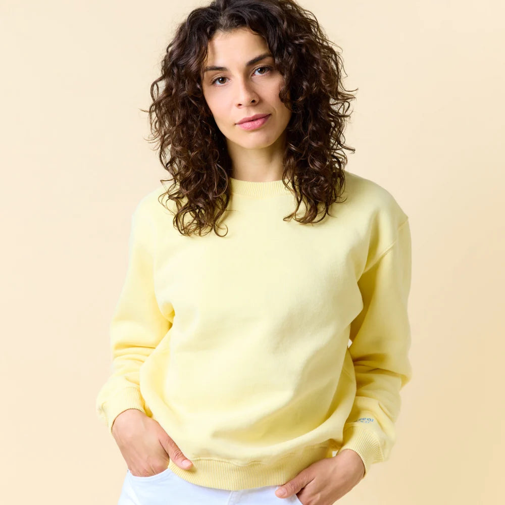 Model trägt den buttergelben Kindness Sweater von popeia.