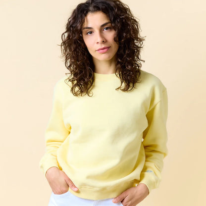 Model trägt den buttergelben Kindness Sweater von popeia.