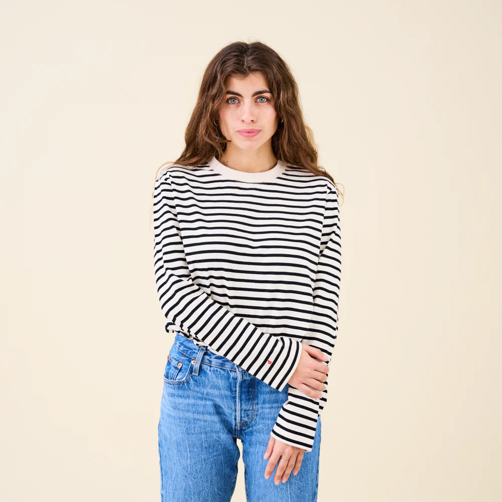 Vorderansicht des schwarz-off-white gestreiften popeia Langarmshirts, locker getragen und mit Jeans kombiniert.